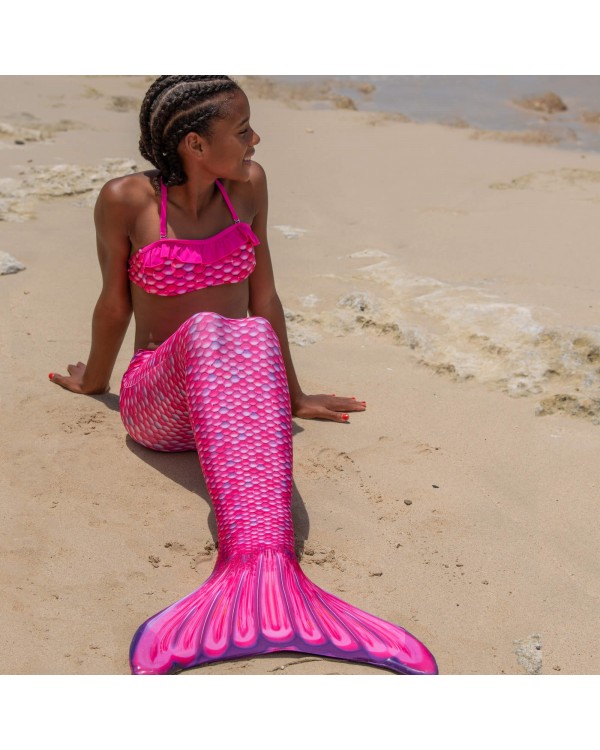 Mädchen am Strand mit einer rosa Meerjungfrauenflosse