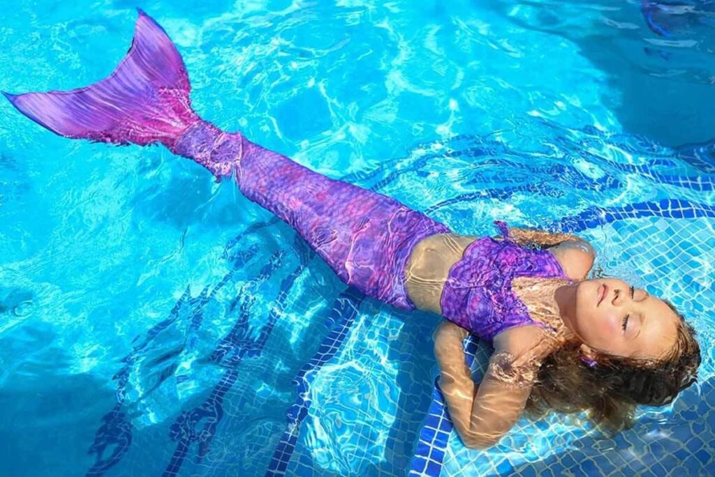 Meerjungfrau im Wasser mit einer violetten Meerjungfrauenflosse