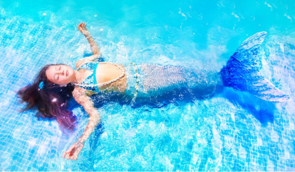 Mädchen mit Meerjungfrauenflosse im Wasser
